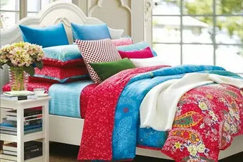 Vibrant bedding set with colorful pillows and floral patterns in a cozy bedroom setting.